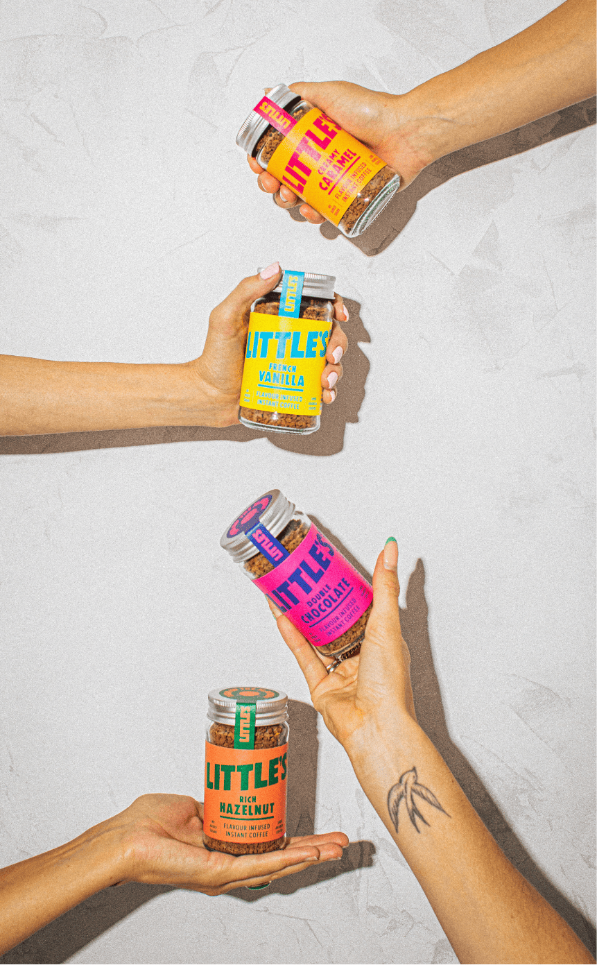 Hands holding Little's glass coffee jars