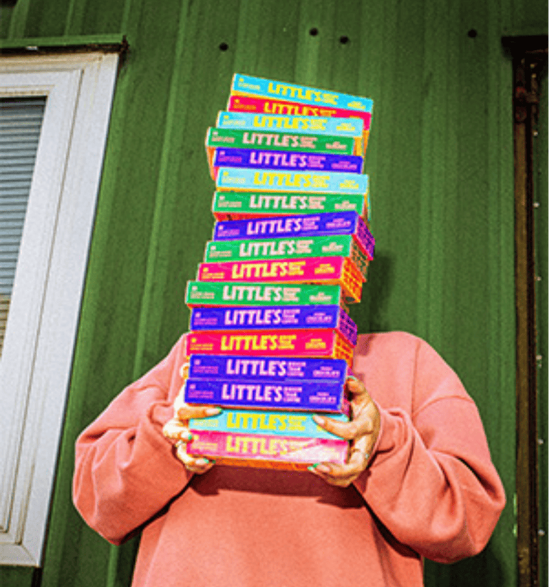 Person holding a tall stack of Little's coffee boxes